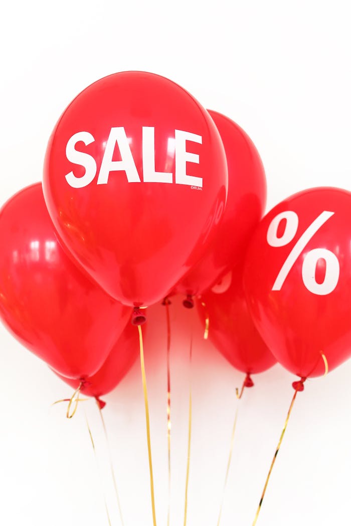 Bright red balloons with sale and percentage symbols for promotional advertising.